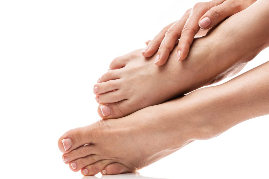 Closeup of female feet and hands with soft skin, french manicure and pedicure on white background