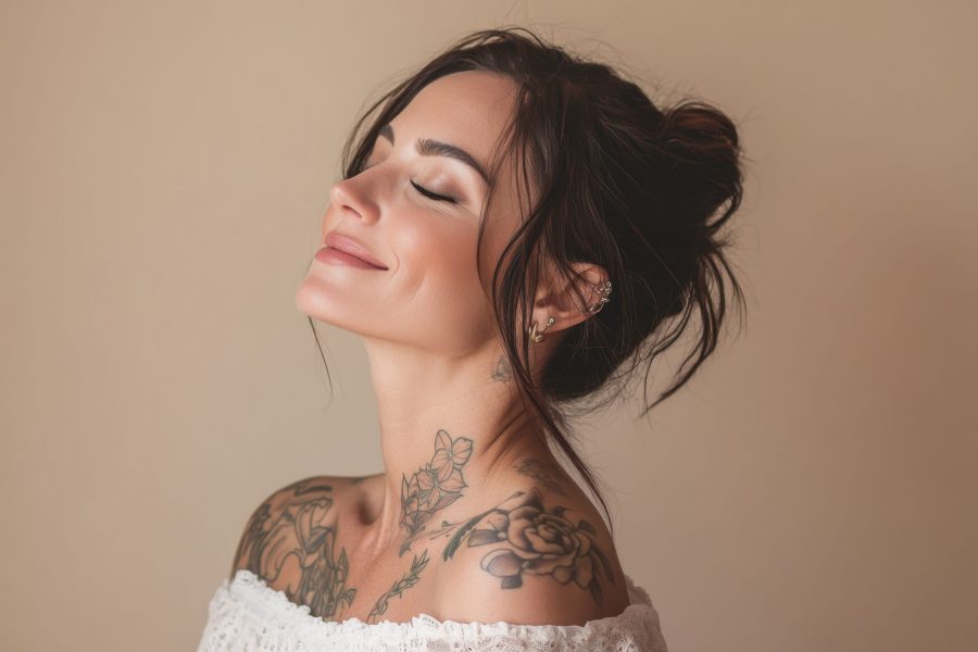 A close up of a woman's face with tattoos and her eyes closed